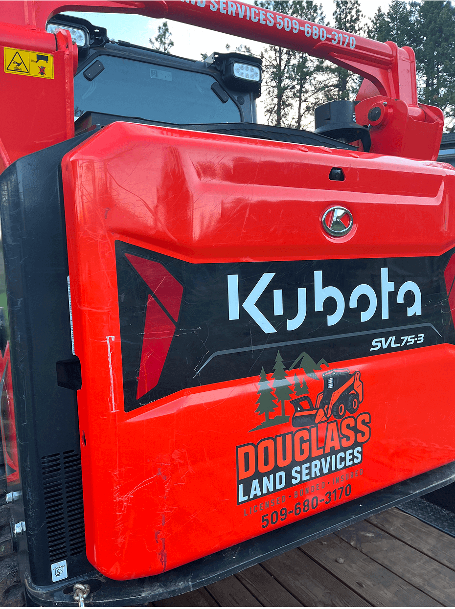 Red Kubota machinery with Douglass Land Services logo.